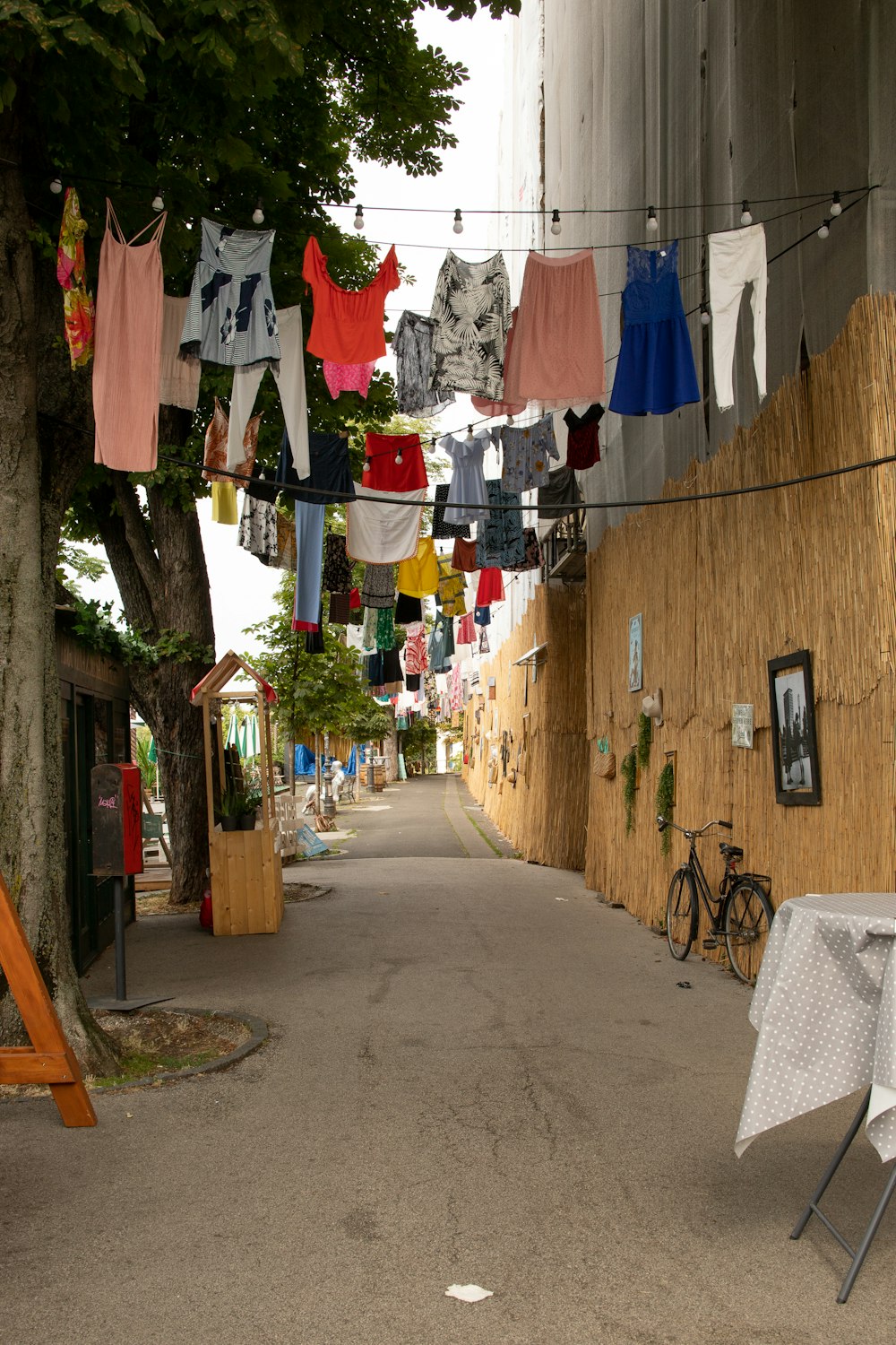 a row of clothes on a line in a narrow alley
