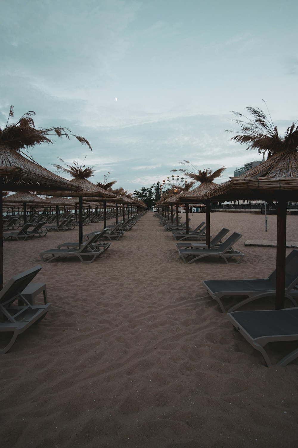 a beach with chairs and umbrellas