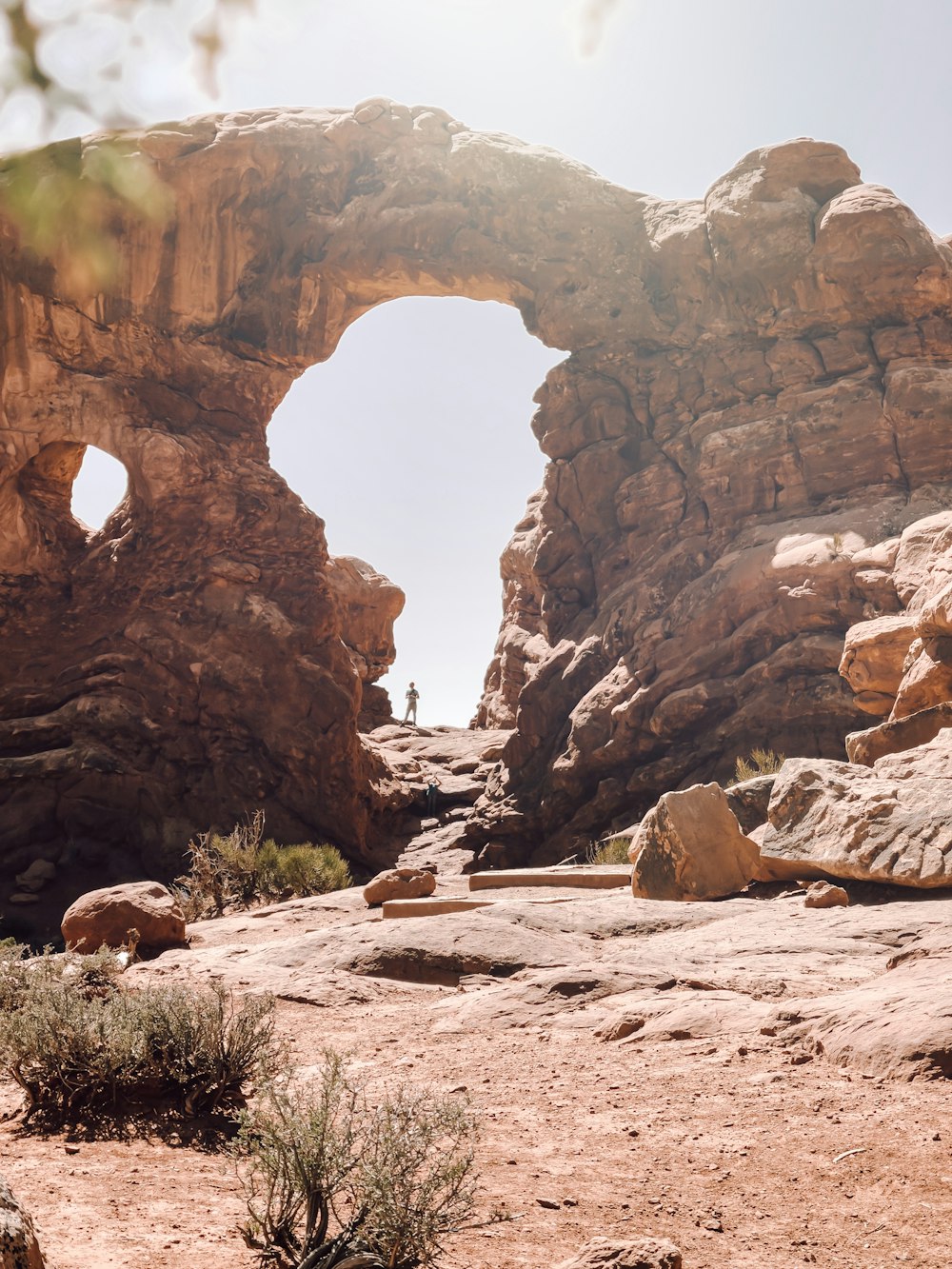 a person standing in a large rock arch