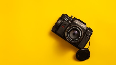 a black camera on a yellow background