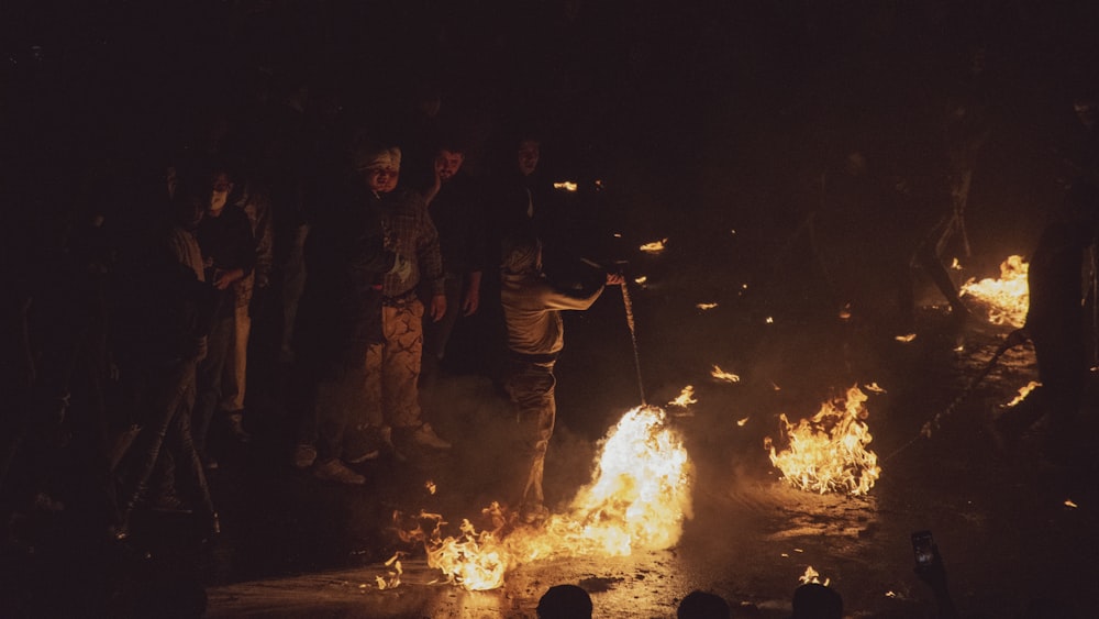 a group of people standing around a fire