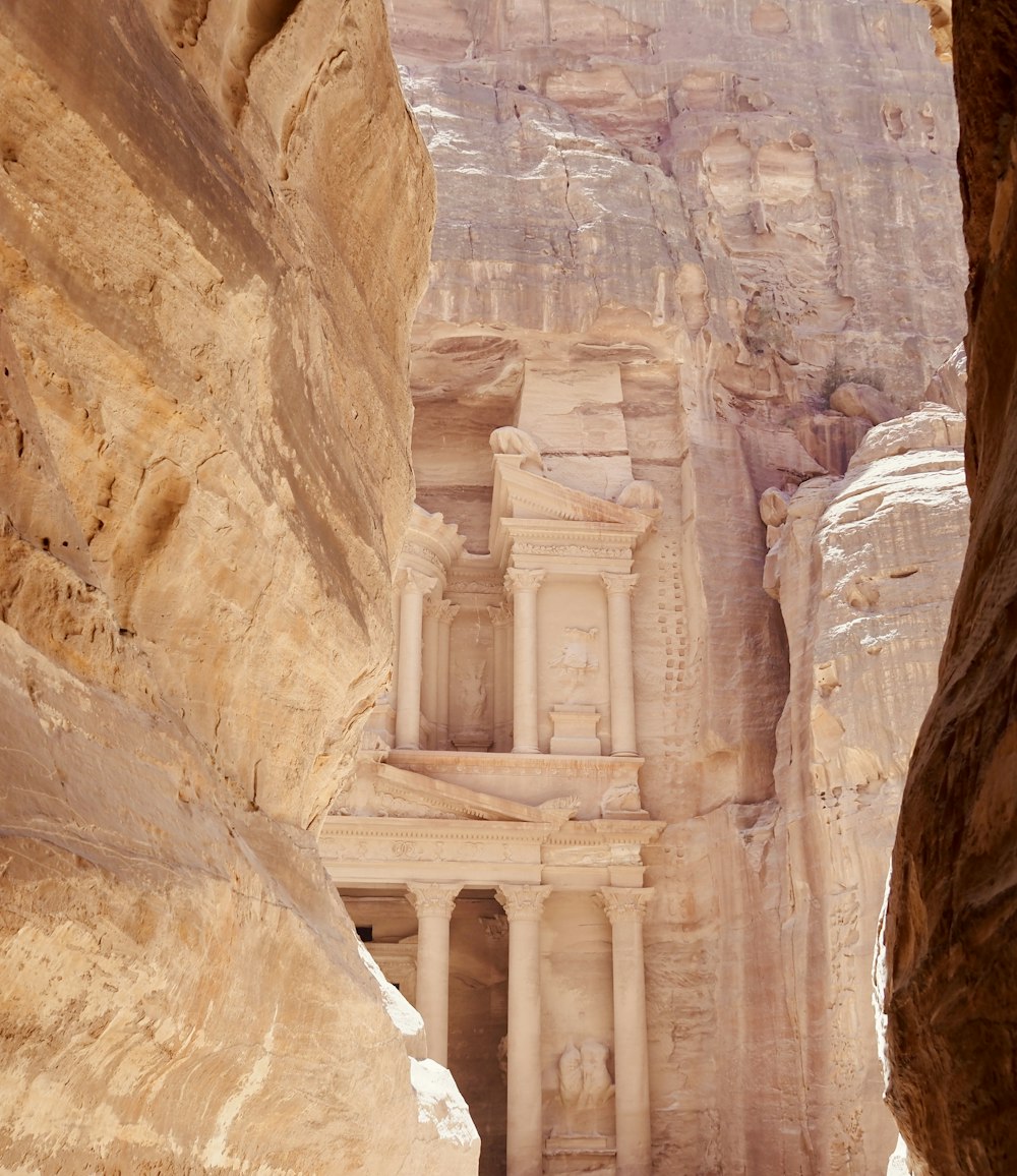 a stone building in a rocky canyon with Petra in the background