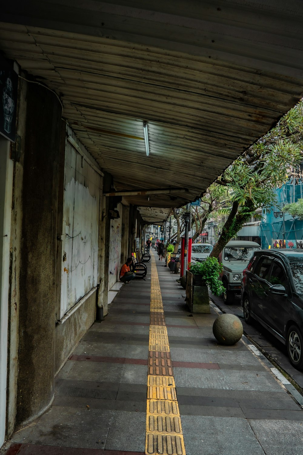 a sidewalk with cars and people