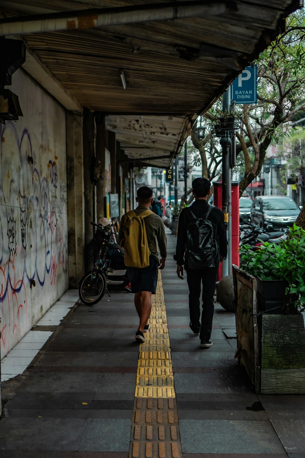 a couple of men walking down a sidewalk