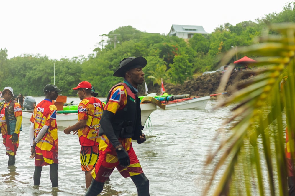 a group of people in clothing walking in a river