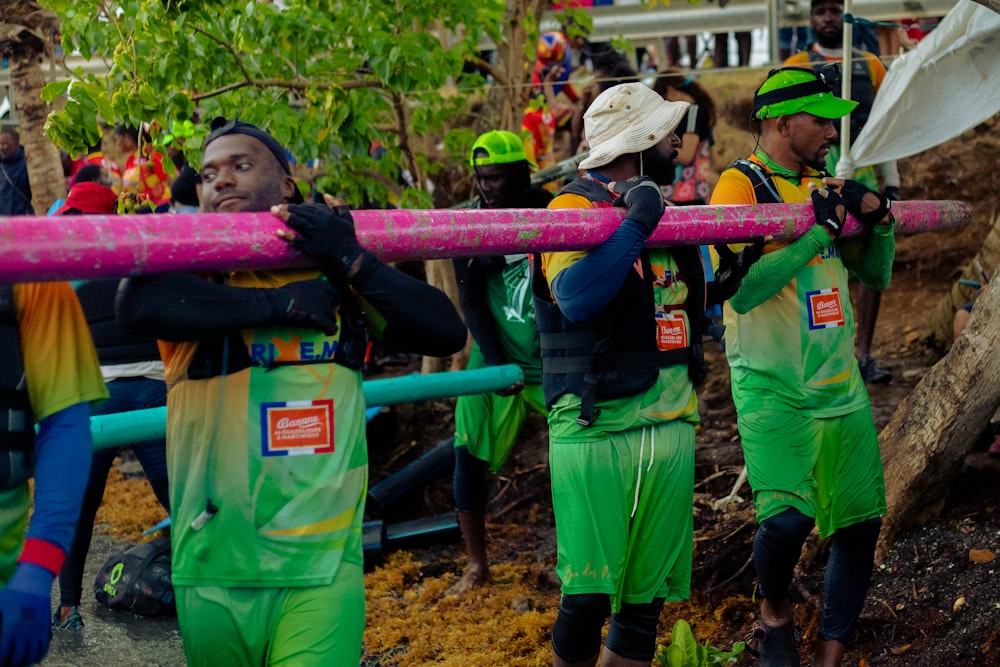 a group of people in green uniforms holding a large sword