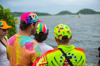A group of people wearing colorful sun hats at a beach.