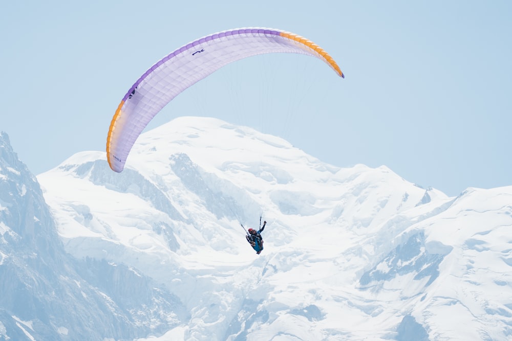 une personne parachutée au-dessus d’une montagne enneigée