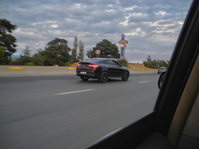A spacious black Innova Crysta with tinted windows on a highway.