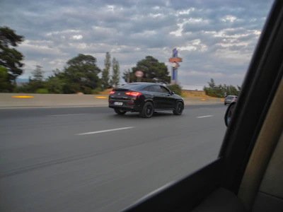 A sleek black and red Kalash Cabs vehicle cruising on a scenic highway in Bihar.