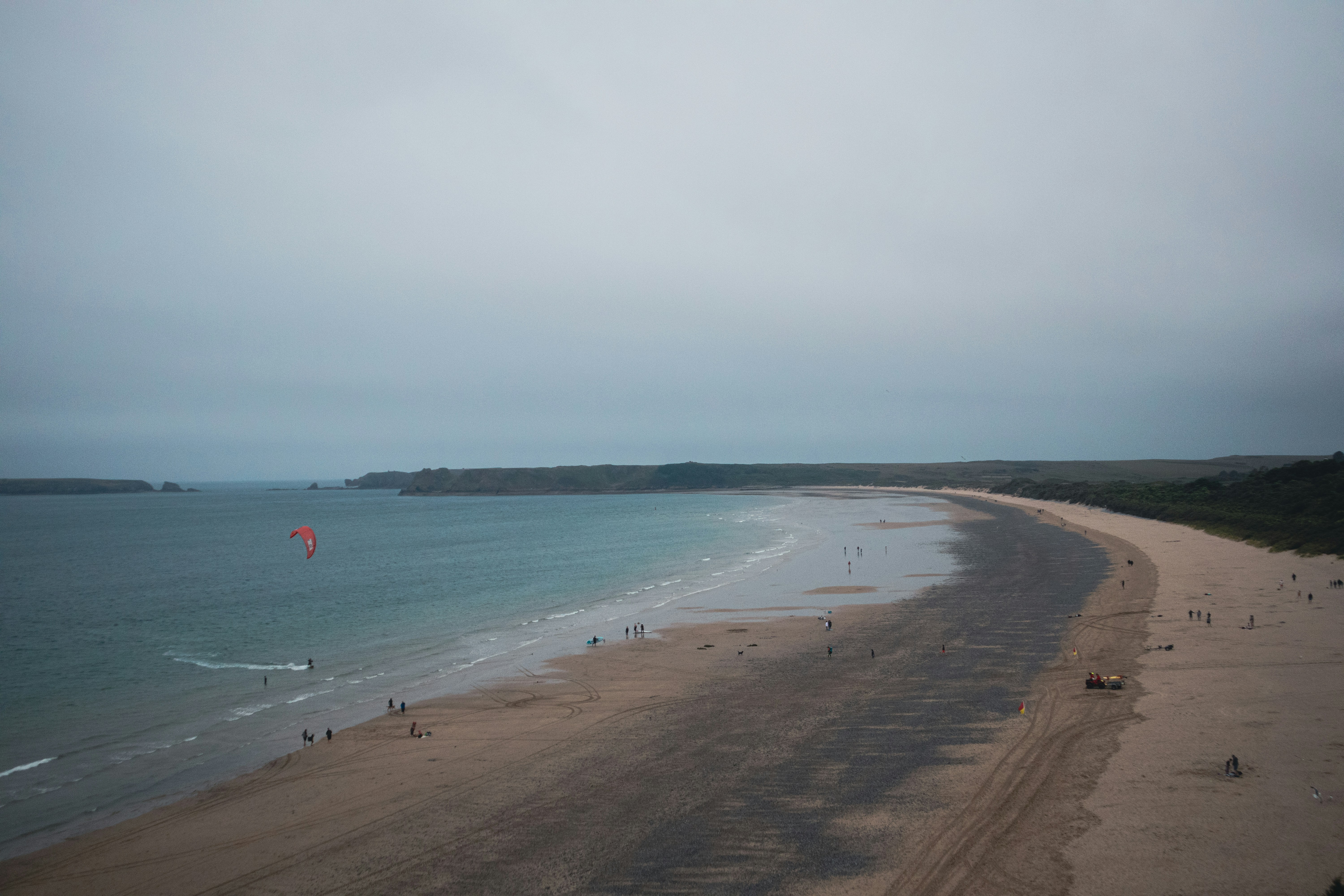 Personne jouant au cerf-volant sur une plage de sable galloise