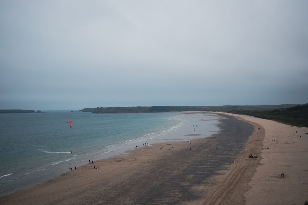 Eine Person, die einen Drachen am Strand steigen lässt