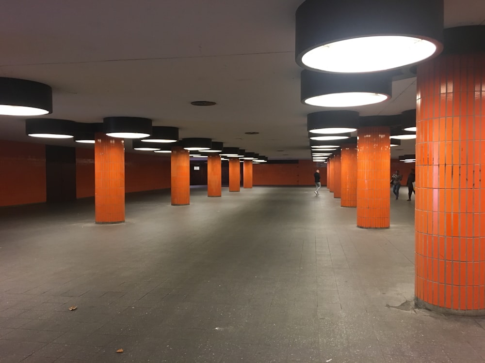 a long hallway with orange pillars