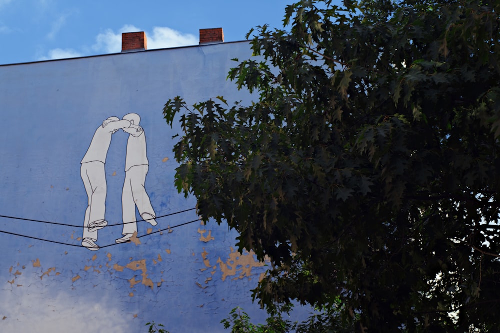 a couple of people painting on a wall