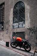 Rear view of a customized Jawa 42 with neon orange accents parked against an urban Indian street mural.