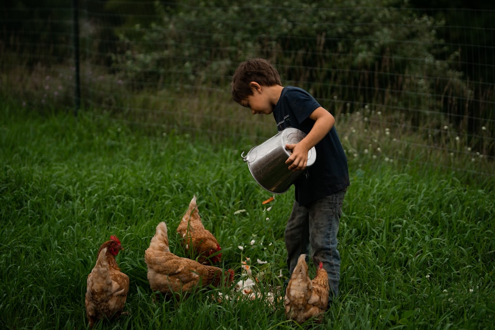 a boy holding a bucket of water