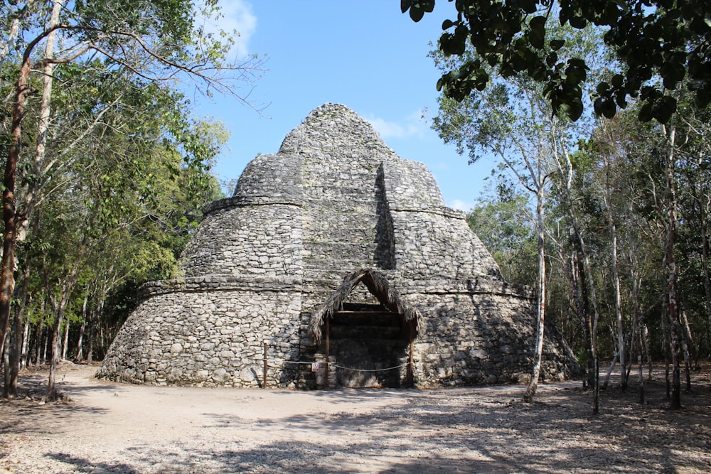 a stone building with a door with Coba in the background