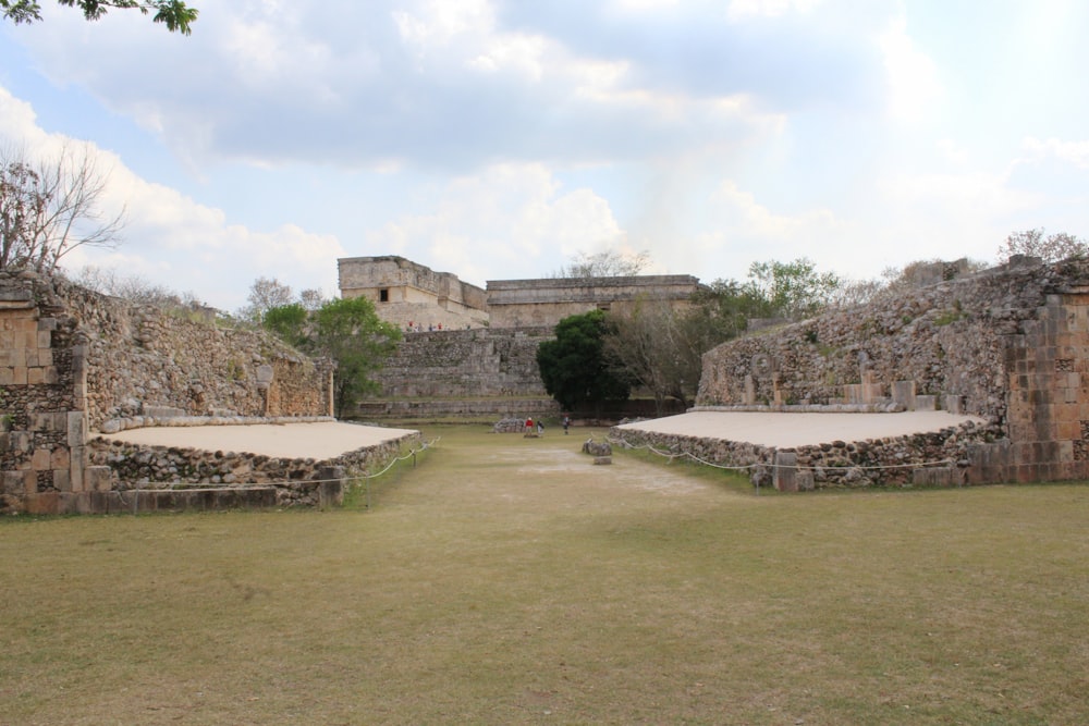 a stone building with a grass field