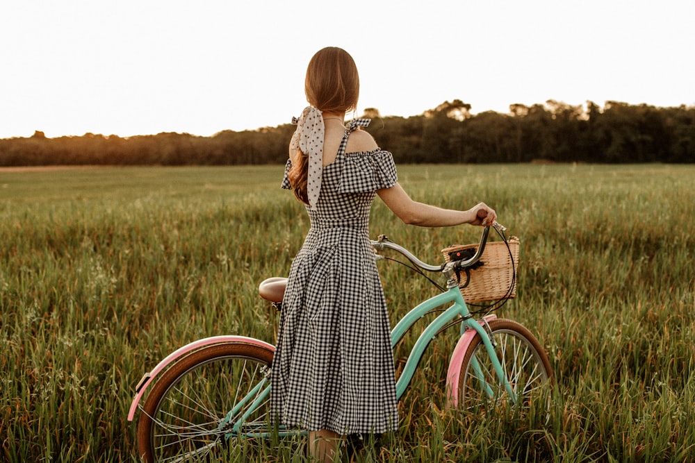 a person holding a bike in a field