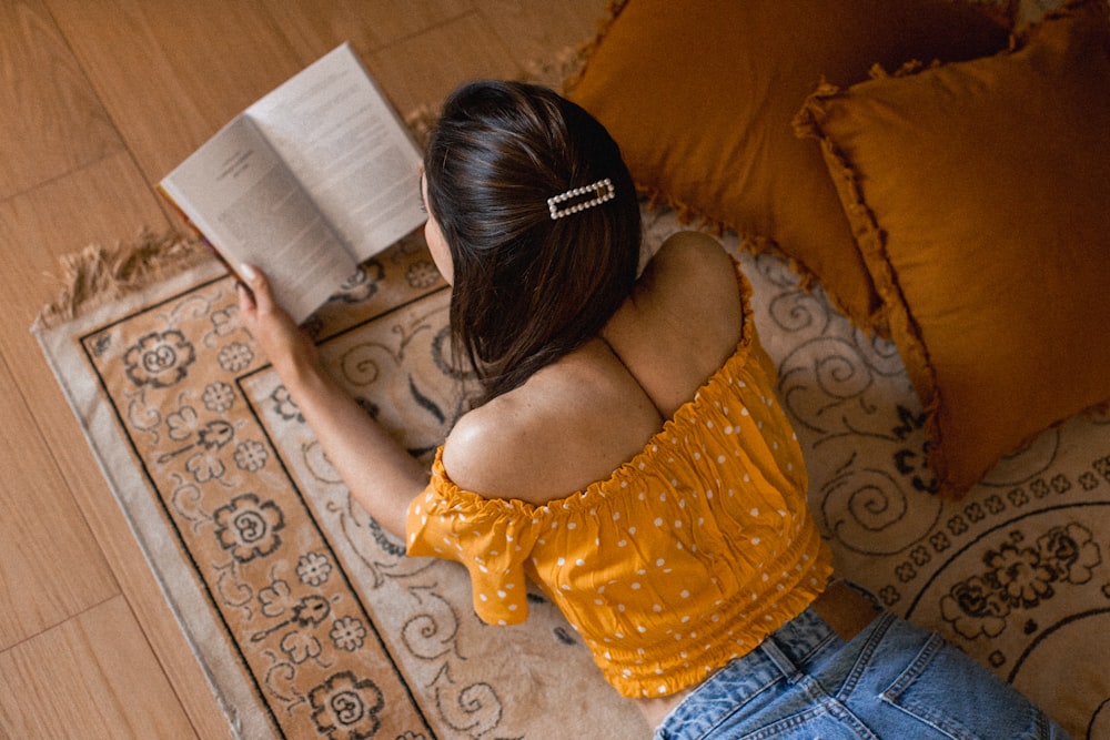 a person lying on a couch reading a book