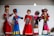 Five decorative dolls are dressed in traditional, colorful costumes showcasing intricate embroidery and accessories. Each doll's attire reflects a different style rich in cultural design, featuring vibrant colors and detailed ornamentation. The dolls are arranged in a display, emphasizing the artistic craftsmanship.