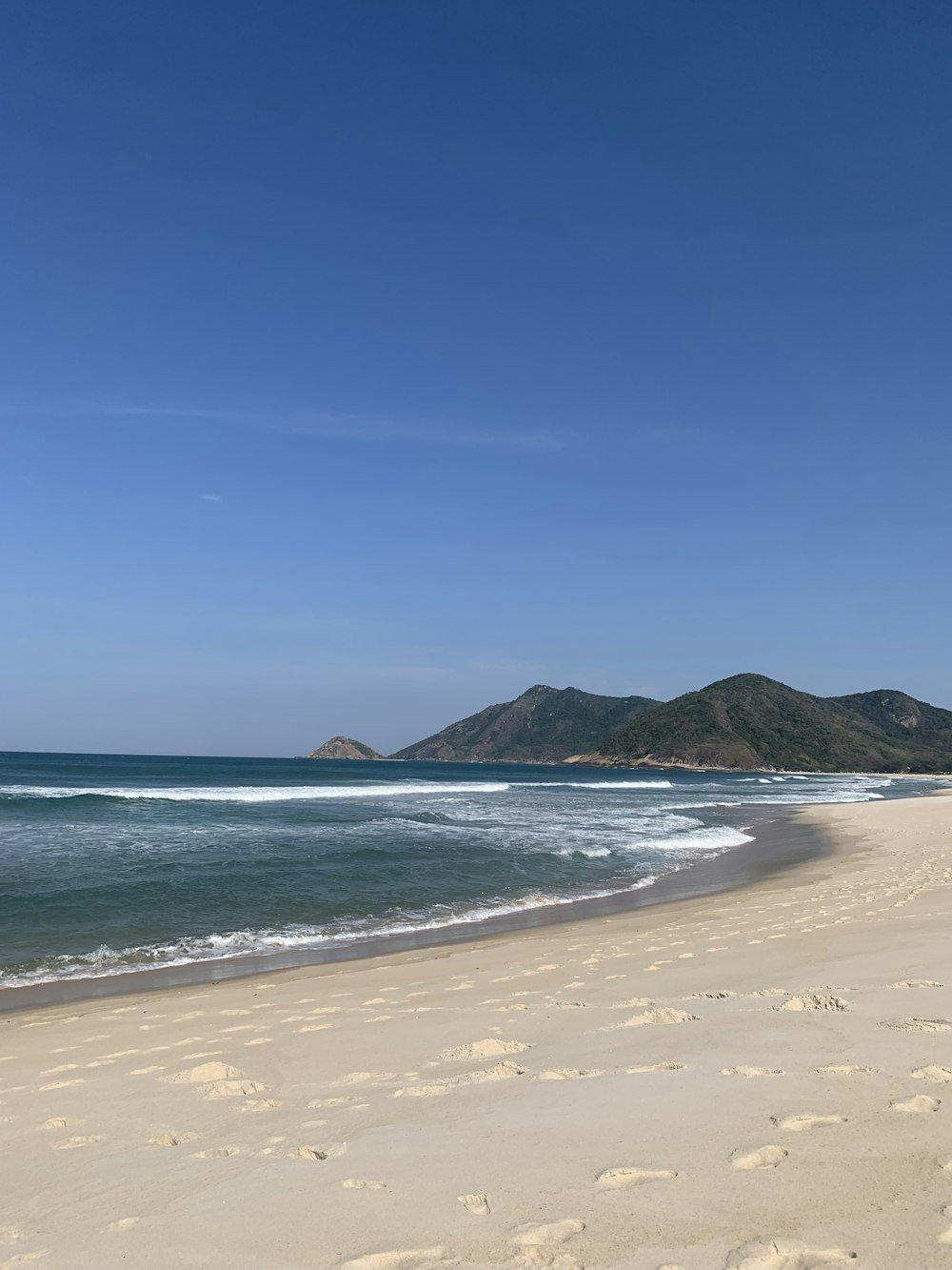 a beach with a hill in the background