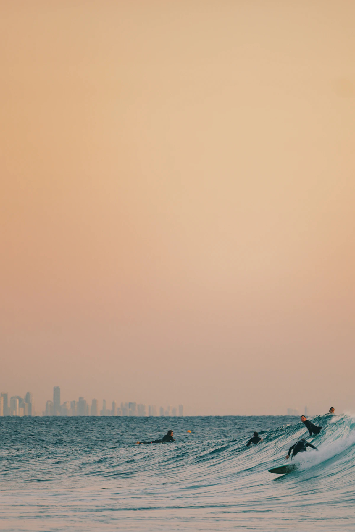 Group of surfers riding a wave on the Gold Coast. Photo by Josh Withers on Unsplash
