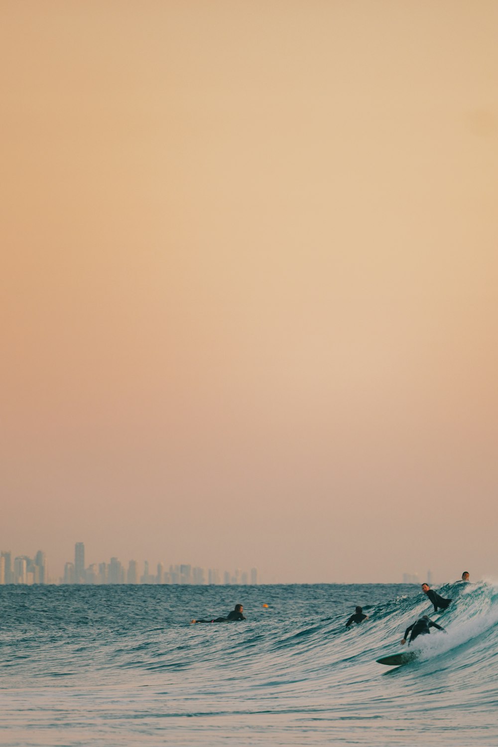 a group of surfers riding a wave