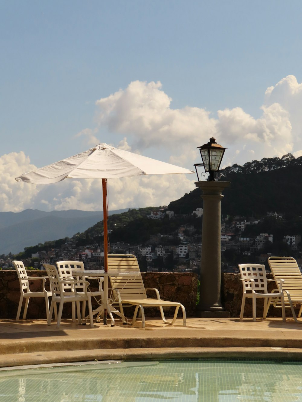 a pool with chairs and umbrella