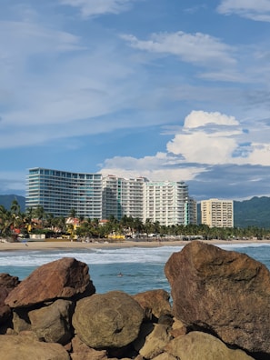 a rocky beach with a city in the background