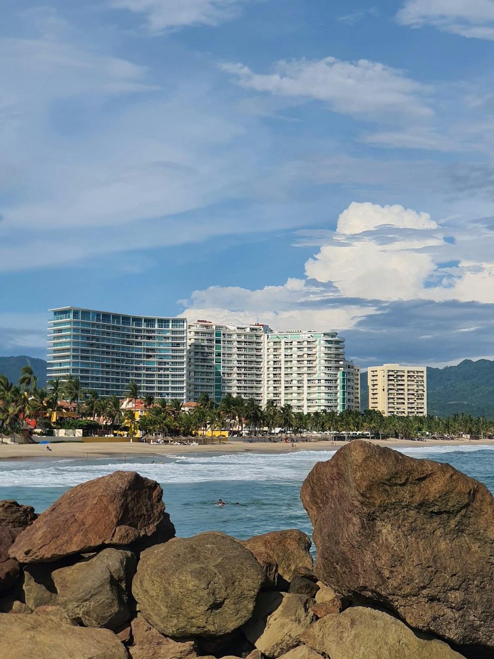 a rocky beach with a city in the background