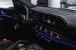 Close-up of a car dashboard with metallic gray details and soft blue ambient lighting.