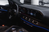 Close-up of a futuristic car dashboard illuminated with blue neon lights.