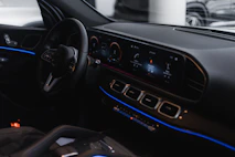 Close-up of a car dashboard with metallic gray details and soft blue ambient lighting.