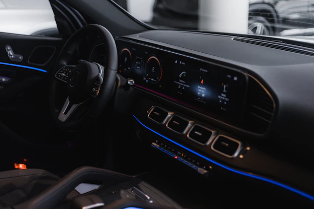A sleek car interior showcasing a modern sound system installation with glowing blue ambient lights