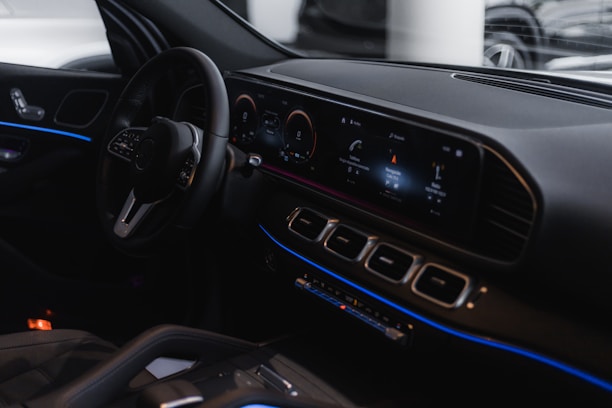 Close-up of a sleek car dashboard with illuminated controls.