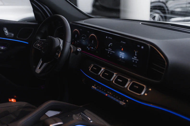 A sleek modern car dashboard illuminated with blue and gold accents.