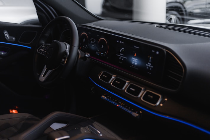 A sleek car dashboard illuminated with modern controls at night