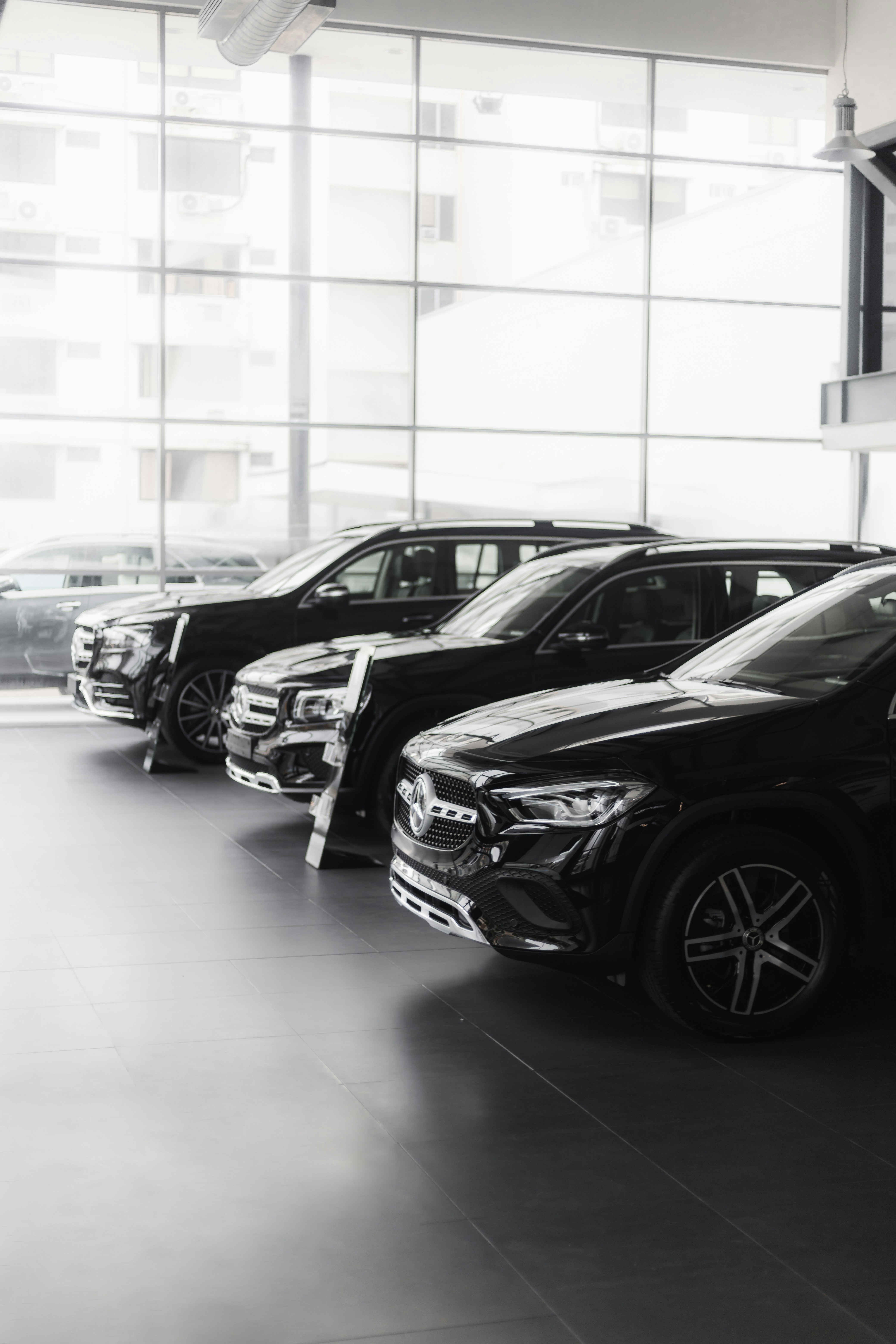 Black luxury SUV with ceramic coating applied, showroom floor with dramatic lighting