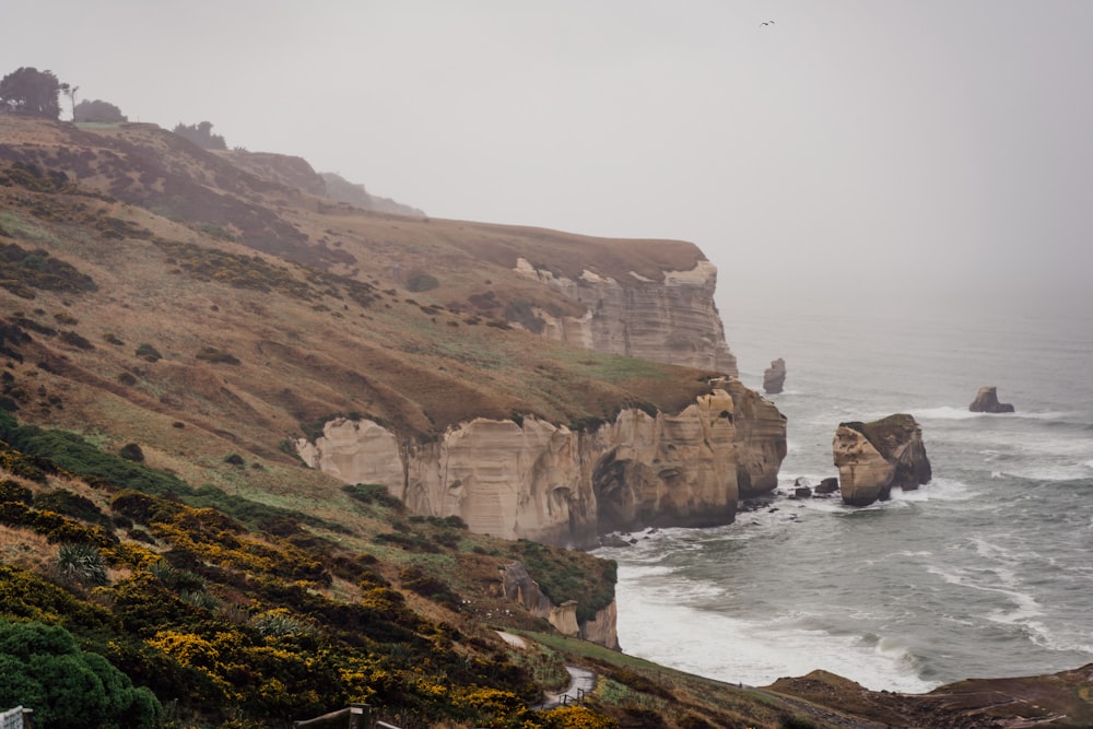 a cliff side with a body of water below