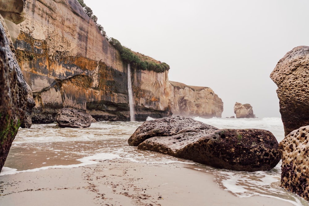 a rocky beach with a waterfall