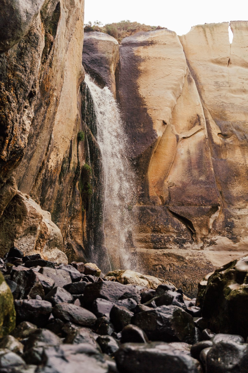 a rocky canyon with a waterfall