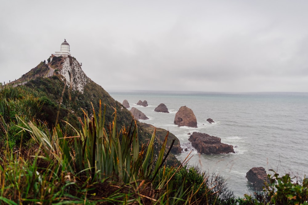 a lighthouse on a rocky cliff over the ocean