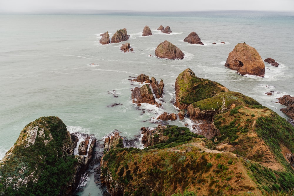 a rocky beach with a body of water in the background