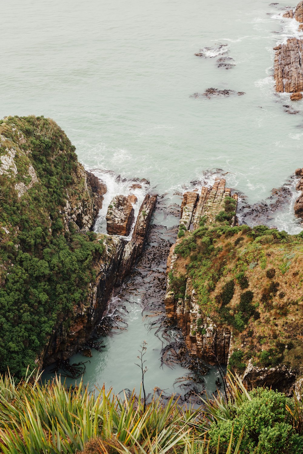 a rocky cliff next to a body of water