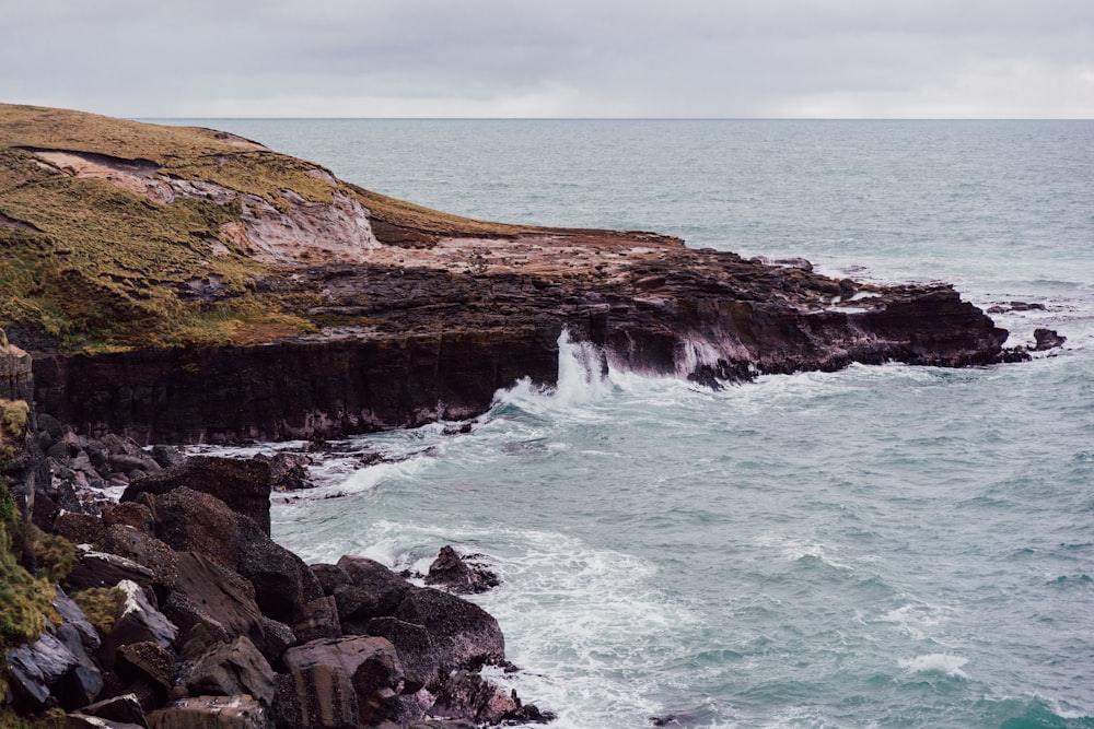 a rocky cliff next to the ocean