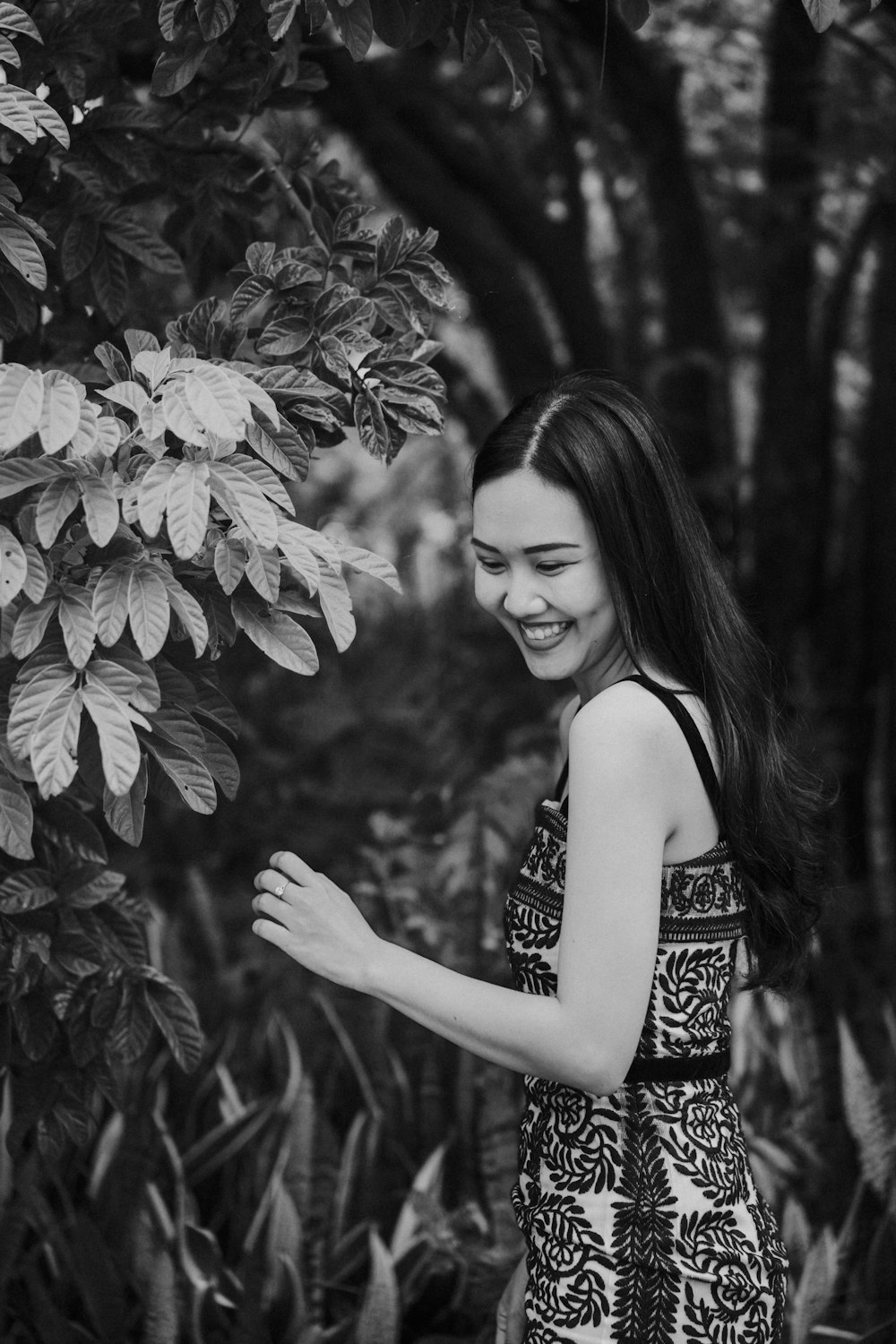 a woman standing next to a tree