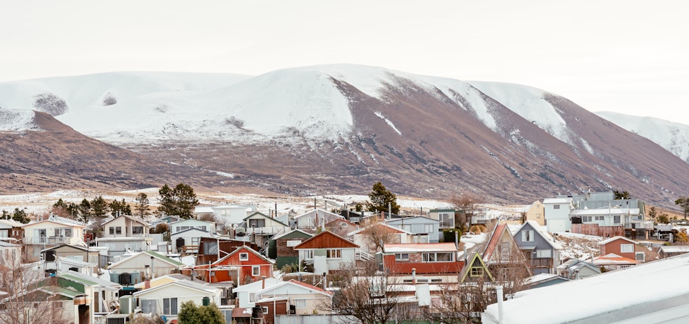 a group of houses in front of a mountain