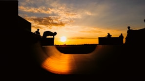 A vibrant sunset backdrop with skaters silhouetted in action.
