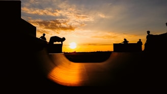 A vibrant sunset backdrop with skaters silhouetted in action.